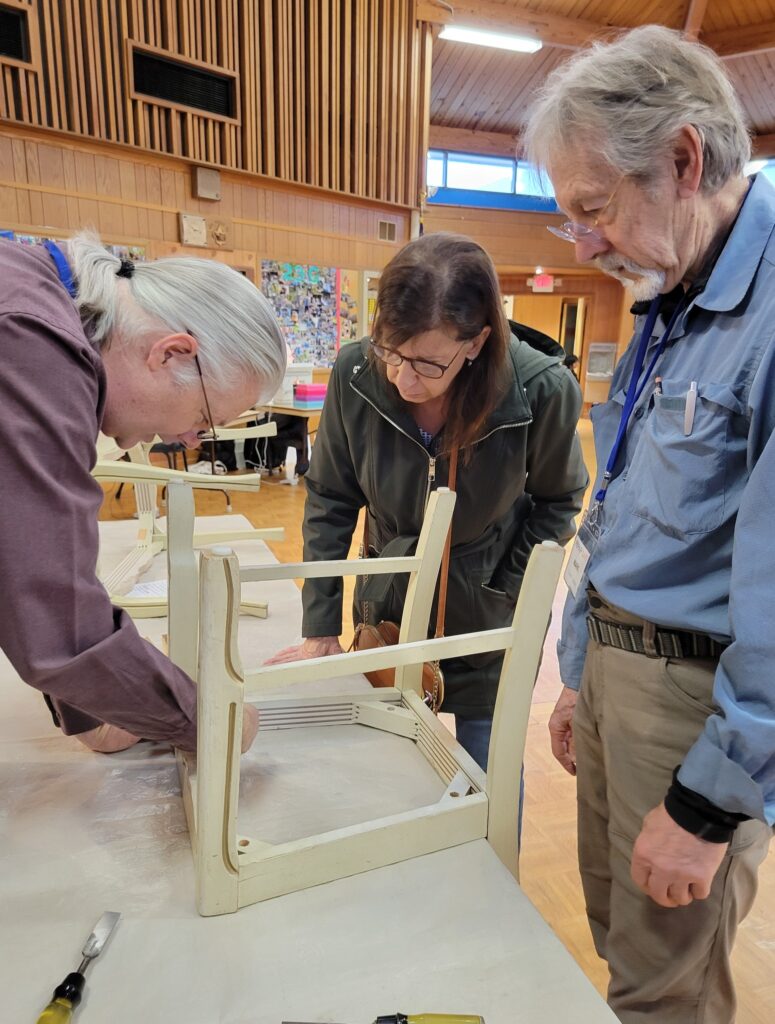 People repairing a chair at Repair Cafe Downingtown.